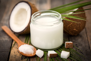 Jar of coconut oil sitting on a wooden table